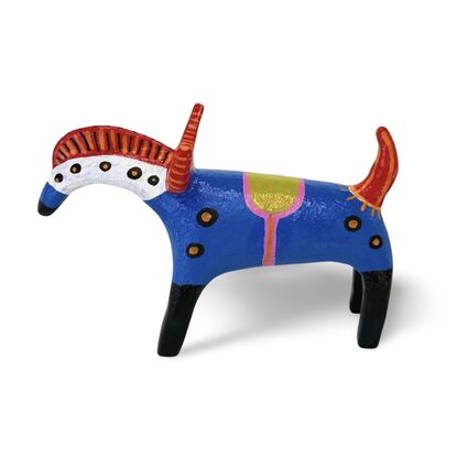 The Horned Wanderer sculpture features a bold blue body with vibrant red, curved horns and black legs, accented by colorful patterns and dotted details. 