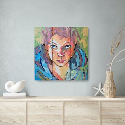 Brightly coloured face of young girl on 3 small canvases (triptych)