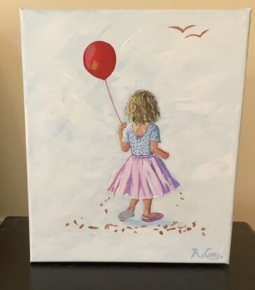 Little girl in pink tutu holding a red balloon.