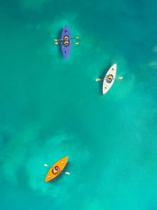 Aerial view of coloured kayaks on turquoise water