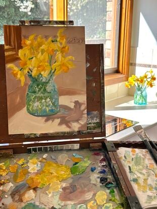 Daffodils in blue glass vase in sunny kitchen spot