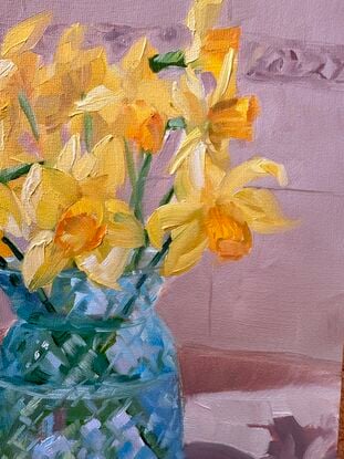 Daffodils in blue glass vase in sunny kitchen spot