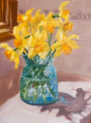 Daffodils in blue glass vase in sunny kitchen spot