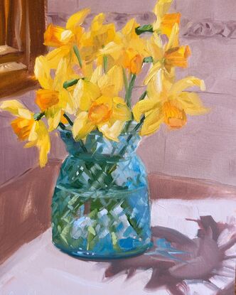 Daffodils in blue glass vase in sunny kitchen spot