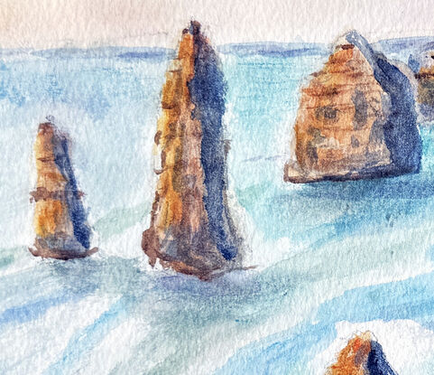 The golden rock cliffs and towers stand in the crystal blue waters