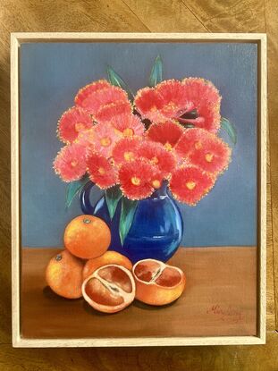 Blood oranges and coral gum blossom in a vase. 