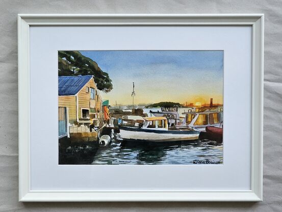 An old boatshed and boats at sunset