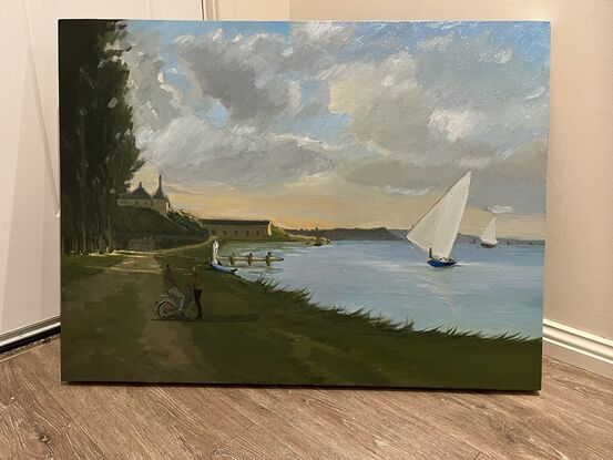 Shoreline at dusk with sailboats and a couple standing by the water