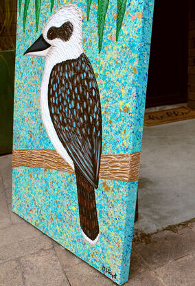 Kookaburra sitting in a tree textured abstract with blue sky and green leaves 