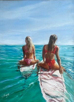 Two tanned women sit astride surfboards watching the ocean’s horizon 