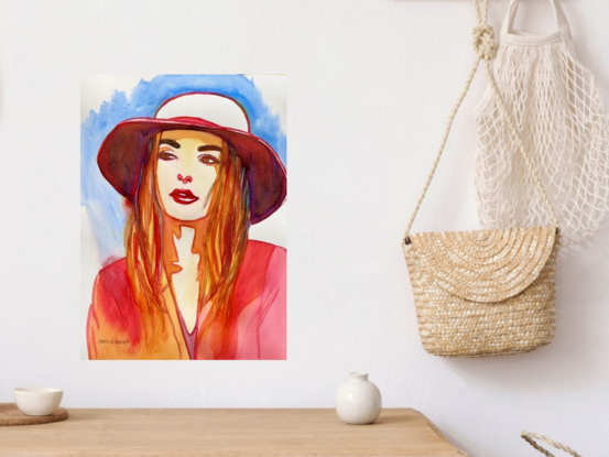 This captivating watercolour artwork captures a moment of thoughtful reflection, as the figure, adorned in a stylish hat, gazes into the distance. The harmonious blend of warm reds and cool blues creates a striking contrast that enhances the subject's serene expression. The delicate brushstrokes and subtle details in the composition evoke a sense of quiet contemplation, making this piece a beautiful exploration of modern elegance and introspection.