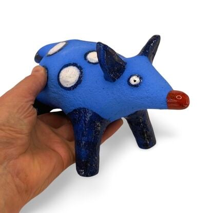 The Spotted Wombat features a playful, abstract rendition of a wombat, glazed in a striking deep blue with contrasting white circular spots and a red snout.