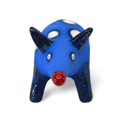 The Spotted Wombat features a playful, abstract rendition of a wombat, glazed in a striking deep blue with contrasting white circular spots and a red snout.