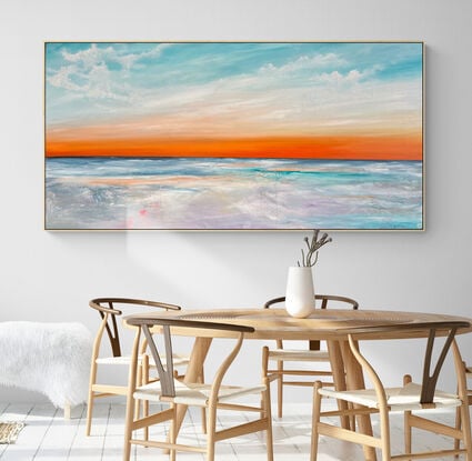 Warm rich sunset sky dotted with streaky clouds  overlooking clear blue seascape and coastline.
