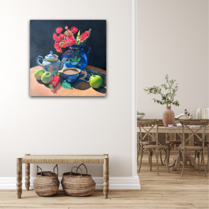 Red gum blossom and bottlebrush in a vase, with green apples and tea. 