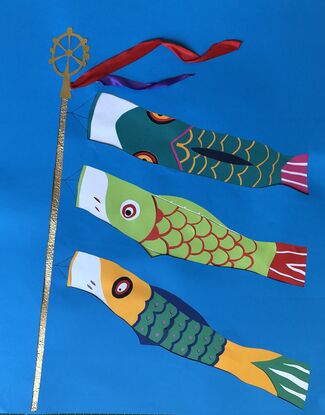 Colourful Japanese carp shaped streamers for Boy's Day Festival in green, yellow and  red against a blue sky background.