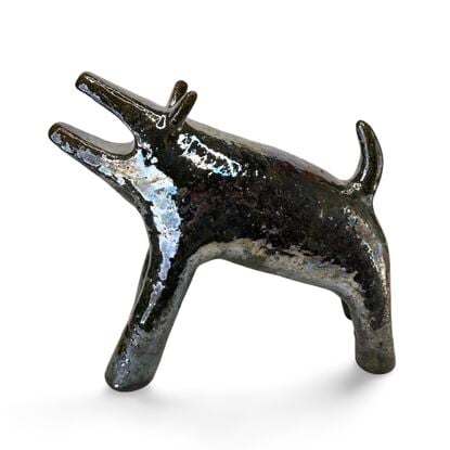 The "Raku Beast" is a striking ceramic sculpture with a glossy, dark Raku glaze that captures the untamed essence of a wild, howling creature. 
Freestanding, signed on back