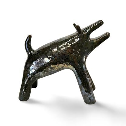 The "Raku Beast" is a striking ceramic sculpture with a glossy, dark Raku glaze that captures the untamed essence of a wild, howling creature. 
Freestanding, signed on back