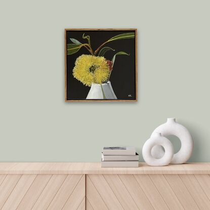 The painting features a bright yellow Eucalyptus Pressiana flower in full bloom, set against a dark background. Its vibrant stamens and green-grey leaves with bug marks are meticulously detailed. The flower rests in a simple white vase, creating a striking contrast with the moody backdrop.