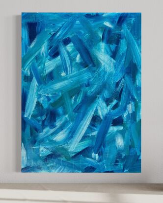 abstract art of large blue green brushstrokes floating across a wood board 