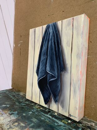 Blue tea towel hanging against panel wall  