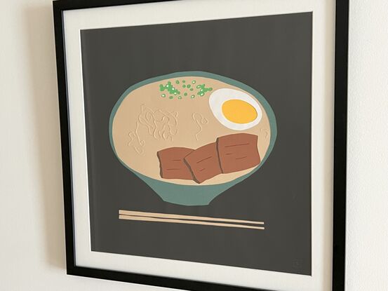 Japanese ramen in green bowl with chopsticks on black background