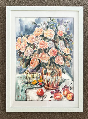 An orange glass vase filled with pink roses in a corner of the home