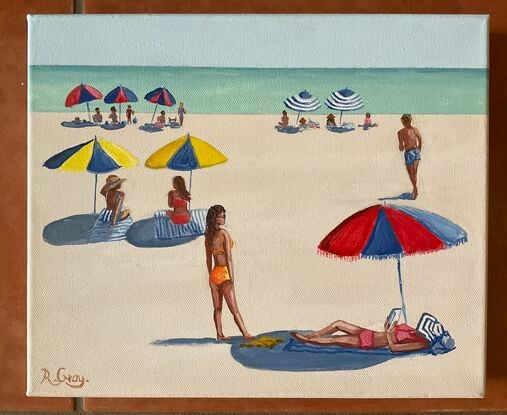 People laying on the beach under beach umbrellas in the sixties with ocean in distance.