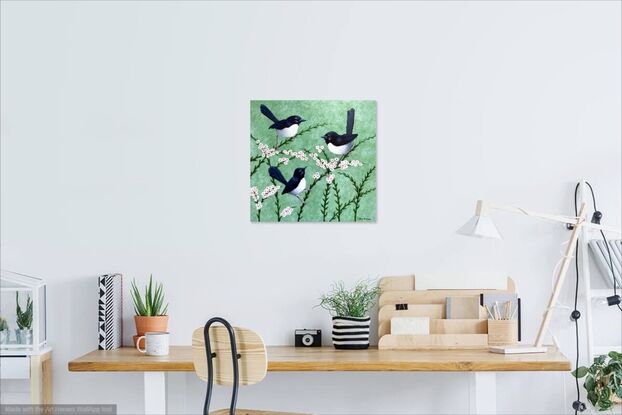 A family of three Willy Wagtails sitting together on pink and white flowers on a pale green background. The image is stretched around to cover the sides of the canvas. The birds are black and white and they are sitting on pink and white flowering branches. 