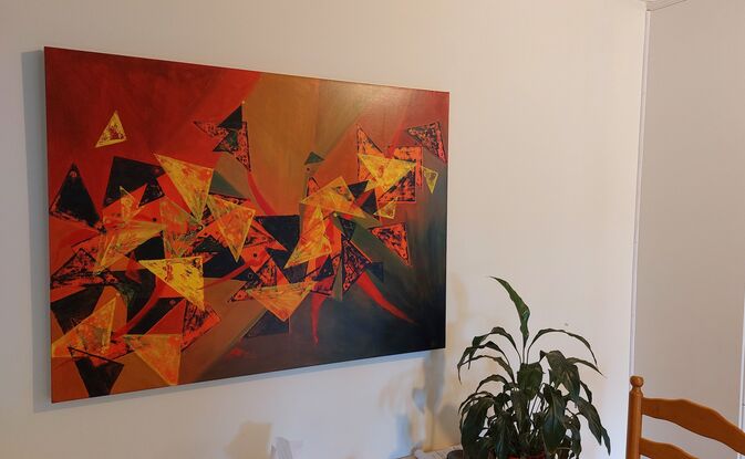 Abstract using yellow and blue triangles floating on a red, orange and green background. 