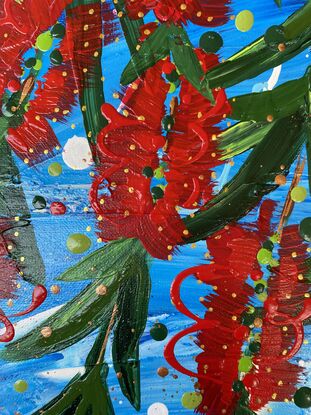 Close up of 10 bright red bottlebrush flowers hanging from a tree with a bright blue sky background. 