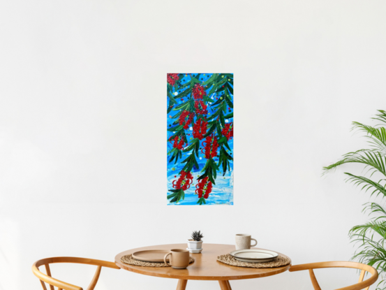 Close up of 10 bright red bottlebrush flowers hanging from a tree with a bright blue sky background. 