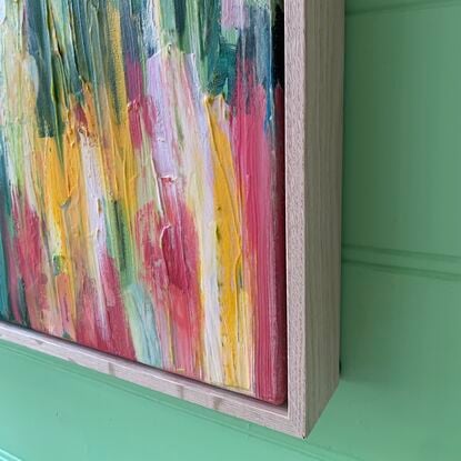 Abstract flora painting of blues, reds, pinks, yellows, orange sand white flowers on canvas, framed in oak.