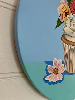 One of four whimsical cupcake paintings, adorned with flowers on circular board, because "happiness is only a cupcake away!"