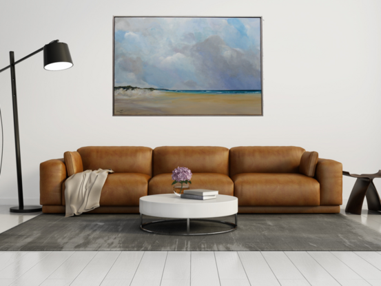 Sand dunes leading into a wide beach scene with calm sea and cloudy sky