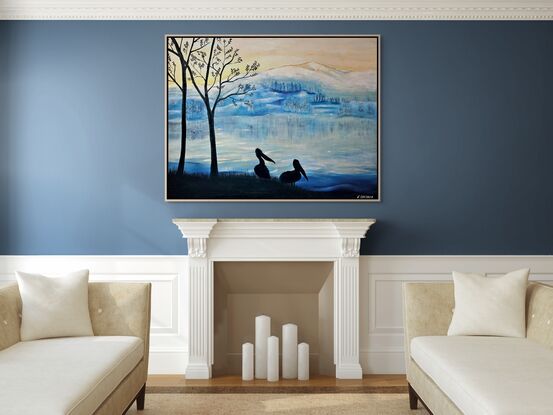 This artwork features a serene, wintry landscape, inspired by the artist's travels through New Zealand. The mountain range in the background, softly covered in snow, reflects the fresh, crisp atmosphere of icy mornings in the region. The hues of blue dominate the scene, evoking the cold, tranquil beauty of the landscape. The sky transitions from soft yellow to cool blues, suggesting the early hours of sunrise or sunset, when the sun gently lights the frosted environment.

In the foreground, silhouetted against this backdrop, stand two pelicans beside bare trees. Their dark forms provide striking contrast and depth, capturing a peaceful moment by the lakeside. The pelicans represent life and stillness, standing against the vast, cold wilderness beyond. The use of silhouette gives the artwork a contemplative, quiet tone, while the color palette reflects the chilly, fresh feeling of a New Zealand winter morning. The artist's experience of awe at the stunning views and mountain ranges comes through in the artwork’s quiet majesty, where nature's beauty is both stark and peaceful.