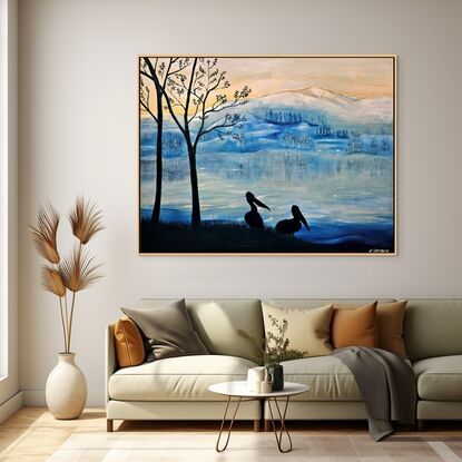 This artwork features a serene, wintry landscape, inspired by the artist's travels through New Zealand. The mountain range in the background, softly covered in snow, reflects the fresh, crisp atmosphere of icy mornings in the region. The hues of blue dominate the scene, evoking the cold, tranquil beauty of the landscape. The sky transitions from soft yellow to cool blues, suggesting the early hours of sunrise or sunset, when the sun gently lights the frosted environment.

In the foreground, silhouetted against this backdrop, stand two pelicans beside bare trees. Their dark forms provide striking contrast and depth, capturing a peaceful moment by the lakeside. The pelicans represent life and stillness, standing against the vast, cold wilderness beyond. The use of silhouette gives the artwork a contemplative, quiet tone, while the color palette reflects the chilly, fresh feeling of a New Zealand winter morning. The artist's experience of awe at the stunning views and mountain ranges comes through in the artwork’s quiet majesty, where nature's beauty is both stark and peaceful.