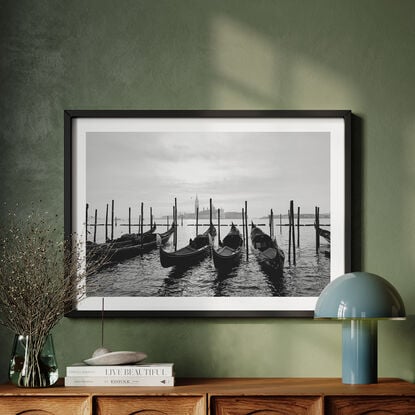 Gondolas docked at the Grand Canal in Venice with a view of a Church in the distance