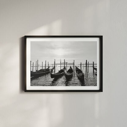 Gondolas docked at the Grand Canal in Venice with a view of a Church in the distance