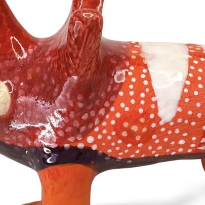 The Spotted Wombat features a playful, abstract rendition of a wombat, glazed in a striking deep blue with contrasting white circular spots and a red snout.