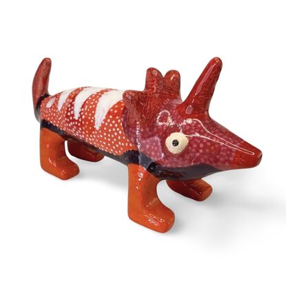 The Spotted Wombat features a playful, abstract rendition of a wombat, glazed in a striking deep blue with contrasting white circular spots and a red snout.