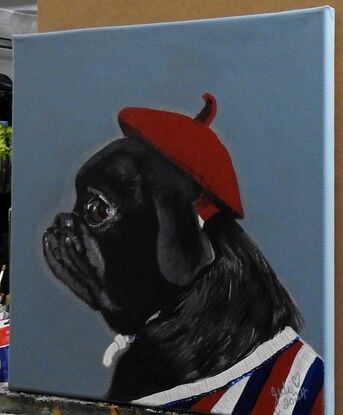 Gorgeous black pug wearing red beret and sporting a strip