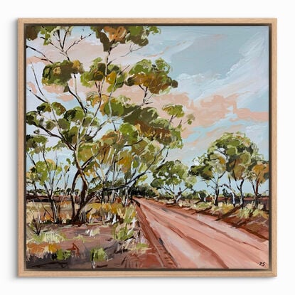 A red track is bordered by swaying gumtrees that make an archway. The blue sky is dotted with peachy clouds.