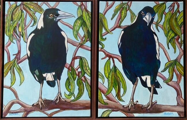 Two paintings that hang side by side. On each painting there is a close up of a magpie sitting on the branches of a gum tree.  Both magpies show all the blues and greens that can be seen amongst their black and white feathers when the sun is shining on them. 