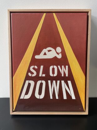 Relaxing pictogram with 'Slow down' painted on the street