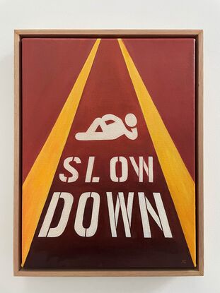 Relaxing pictogram with 'Slow down' painted on the street