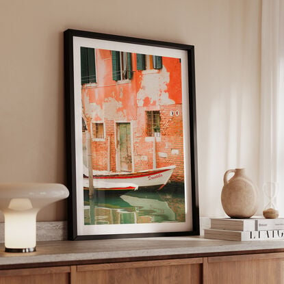 Interesting boat docked along a Venetian Canal with textured brick walls behind