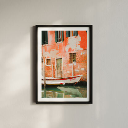 Interesting boat docked along a Venetian Canal with textured brick walls behind