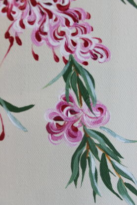 Maroon, red, pink and white Grevillea with green leaves on a light beige background