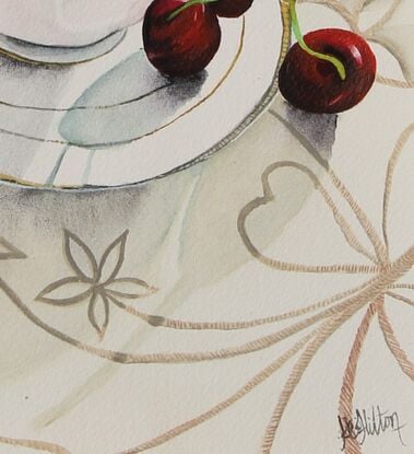 Cup and saucer on a tablecloth with cherrys